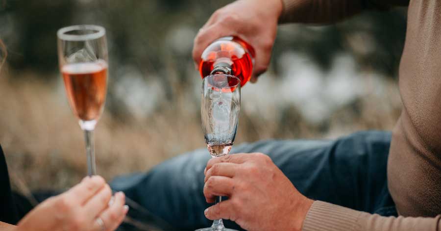 man pouring wine in a champagne glass